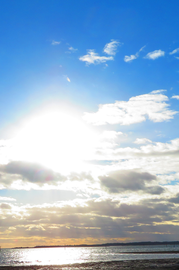 Besprechen von Krankheiten - Sonne scheint am Mittagshimmel hinter Wolken