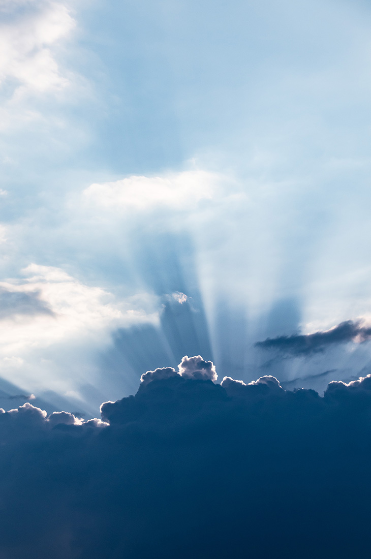 Besprechen von Krankheiten - Sonnenstrahlen hinter Wolken hervorbrechend