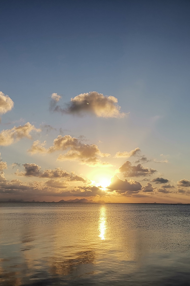 Besprechen von Krankheiten - Sonnenstrahlen hinter Wolken über dem Meer